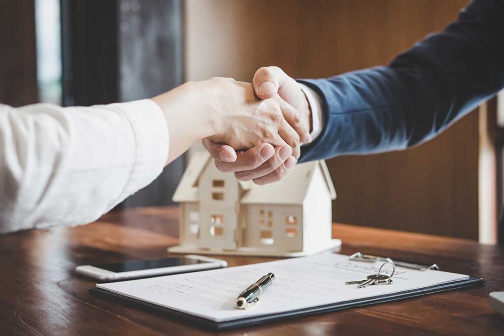 Homebuyer reviews a pre-approval letter and financial documents at a table with a calculator and laptop.